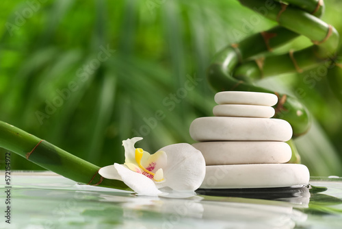 Photography Stack of spa stones, flowers and bamboo in garden