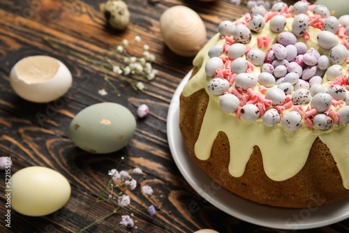 Composition with tasty Easter cake, eggs and gypsophila flowers on wooden background, closeup