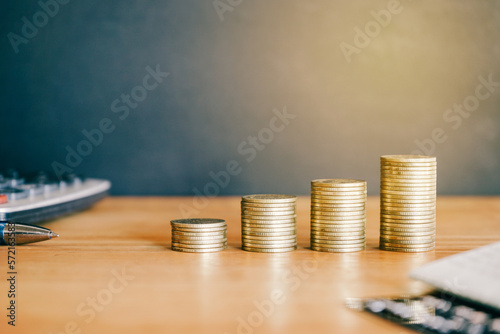 Stack of golden money coin on office desk. Business and financial concept. 