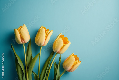 Bouquet of yellow tulips on blue background. Mothers day  Valentines Day  Birthday celebration concept. Greeting card. Copy space for text  top view