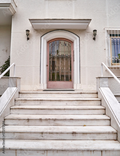 Marble stairs and ornate iron cast door of a vintage family house entrance. Travel to Athens Greece.