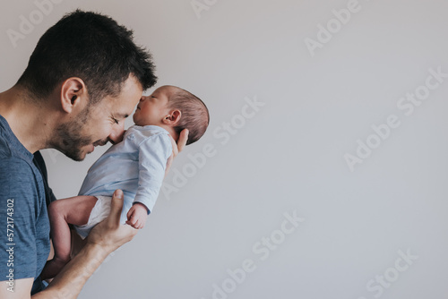 Close-up portrait of happy young father hugging her baby photo