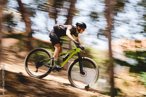 Speed blur of male mountain bike cyclist going downhill