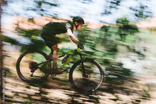 Speed blur of male mountain bike cyclist going downhill