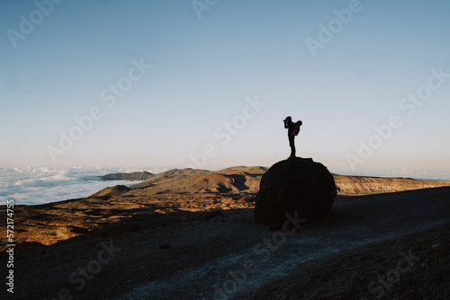 Silhouette of a male hiker taking photo of volcanic landscape