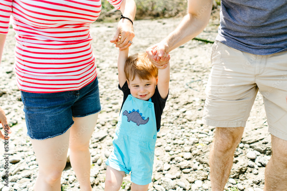 Closeup of a young toddler boy holding hands with his parents Closeup of a young toddler boy holding hands with his parents