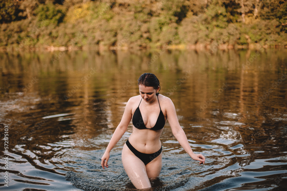 Young seductive woman walking in lake