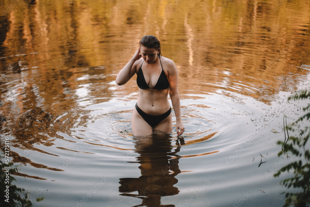 Sensual woman in a bikini standing in water