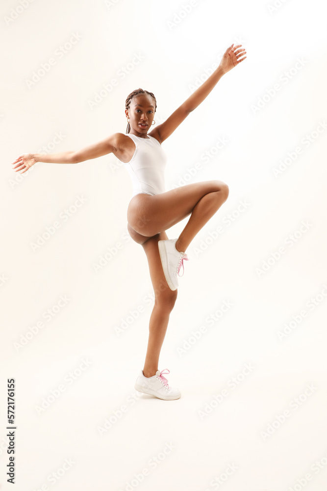 Young woman with perfect body dancing and posing indoor. Vertical mock-up.