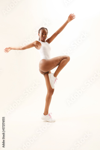 Young woman with perfect body dancing and posing indoor. Vertical mock-up.