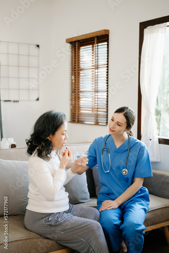 Asian female hands touching old female hand Helping hands holding bottle with pills in hands, reading instruction take care of the elderly concept.