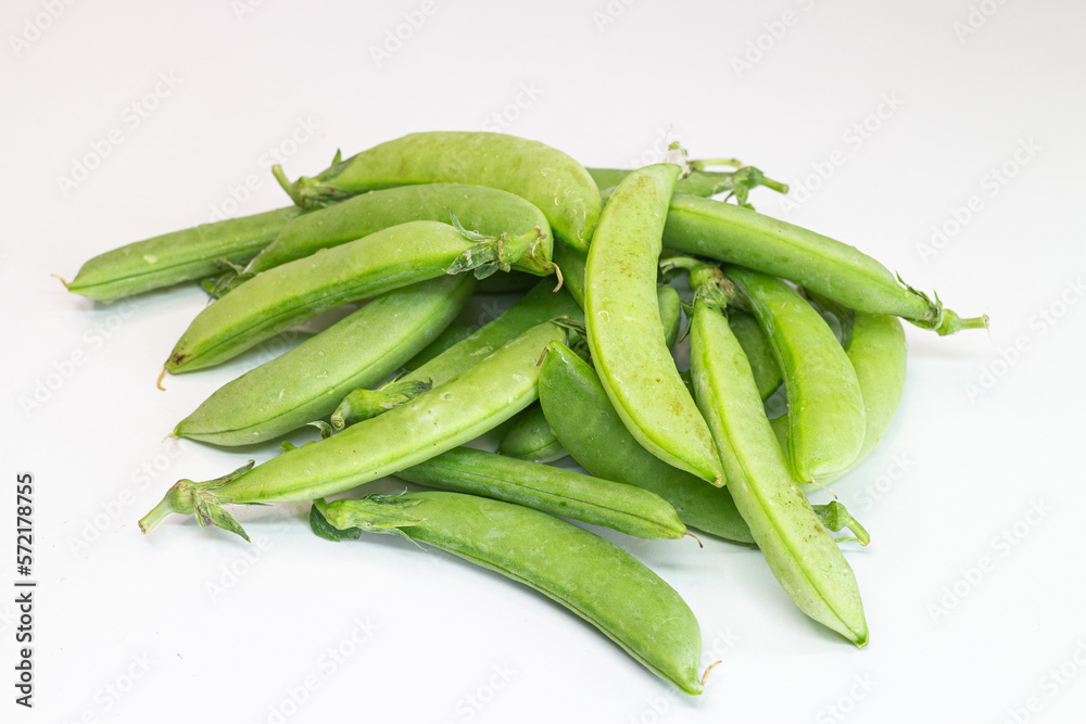 Green peas on a white background. Pea pods on a white background. Green peas on a white background. Pea pods on a white background.