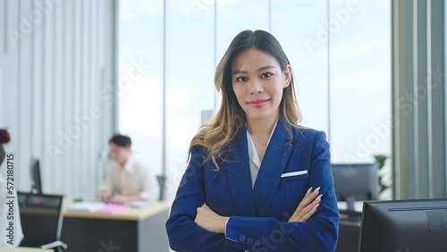 Young asian businesswoman with smilling face standing and crossing arms and looking at the camera