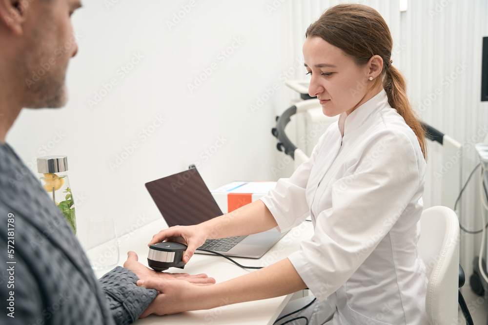 Photo of concentrated female doctor is doing spectral analysis in health center Photo of concentrated female doctor is doing spectral analysis in health center