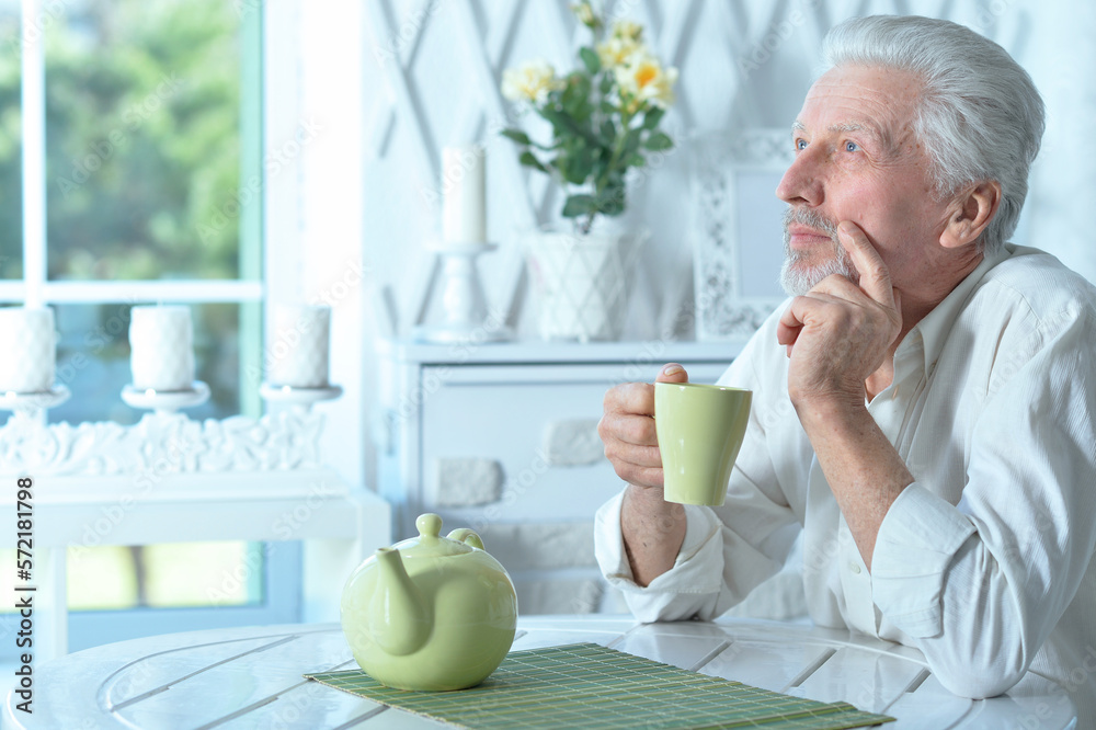 Portrait of smiling old man drinking tea at home Portrait of smiling old man drinking tea at home