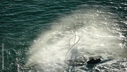 A man flies on a FlyBoard at sunset sea. Aerial. Water extreme sport, azure summer sea with outdoors active people enjoying water sports. Flyboarding and seariding, Recreation and sports concepts. photo