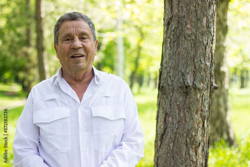 Portrait of senior man in white shirt walking in the park Portrait of senior man in white shirt walking in the park