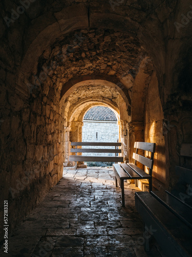 Arch-shaped corridor with bench inside ancient stone monastery of 13th century.