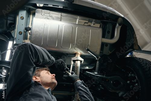 Tablou pe pânză Professional male checking exhaust resonator in the workshop
