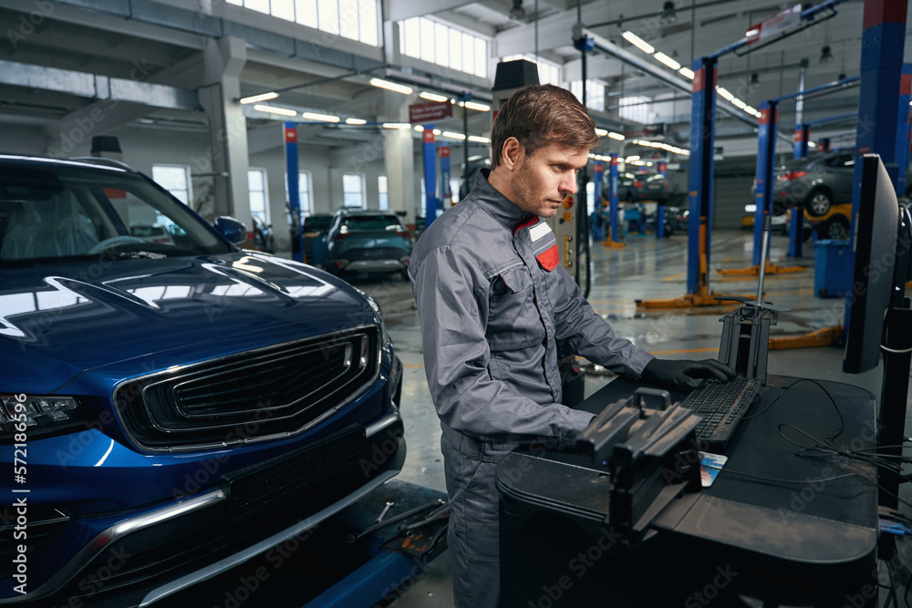 Mechanic inspecting car system in the workshop Mechanic inspecting car system in the workshop