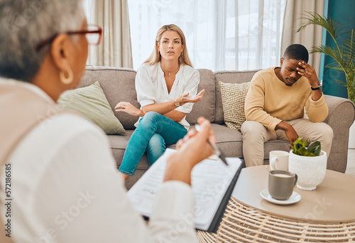 Interracial couple, counseling and therapist with argument and fight on therapy sofa. Tired, relationship stress and marriage problem of people on couch feeling anxiety from divorce conversation