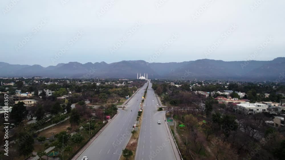 An aerial shot of Faisal mosque Islamabad from a distance with a close view of Faisal revenue in the morning and Margala hills in the background. An aerial shot of Faisal mosque Islamabad from a distance with a close view of Faisal revenue in the morning and Margala hills in the background.