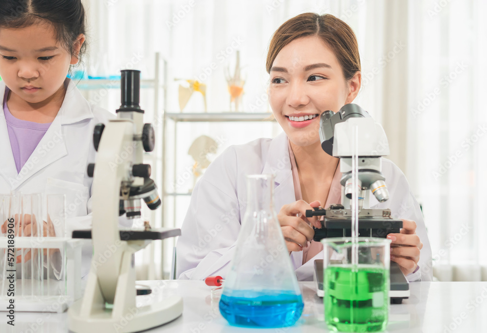 Elementary science class, Female teacher scientist with kid girl in school laboratory, Science laboratory Elementary science class, Female teacher scientist with kid girl in school laboratory, Science laboratory