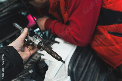 A man removing a stuck injector in diesel engine using press. High quality photo