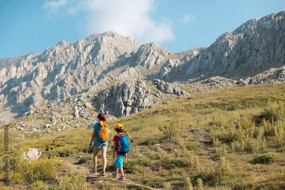 Fototapeta premium mother with a child on a hike walk along the road