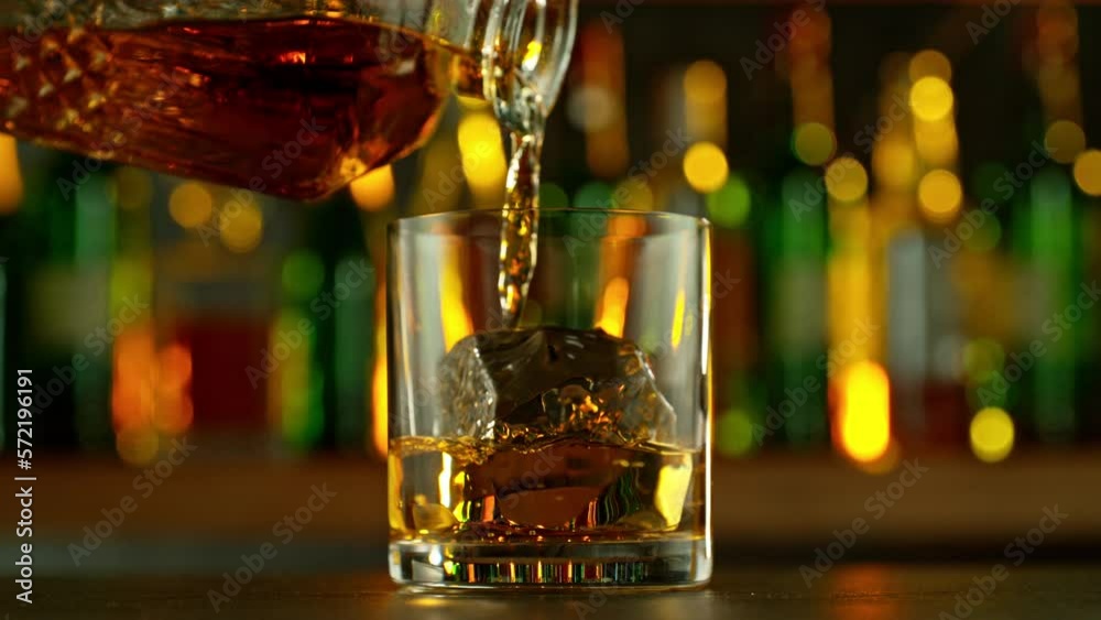 Super slow motion of falling ice cube into whiskey drink, camera motion. Filmed on high speed cinema camera, 1000 fps. Super slow motion of falling ice cube into whiskey drink, camera motion. Filmed on high speed cinema camera, 1000 fps.
