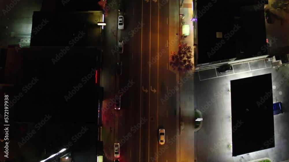 Top down view of skyscrapers street with vehicles passing and city lights at night Top down view of skyscrapers street with vehicles passing and city lights at night