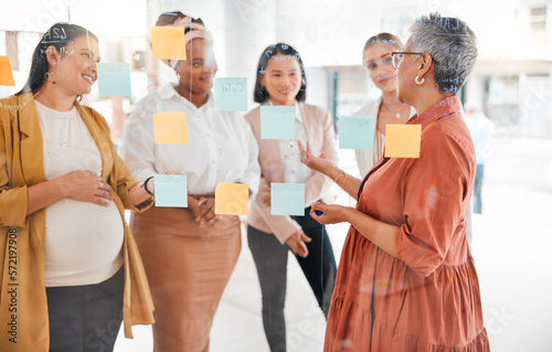 Senior woman in a business meeting for marketing strategy, advertising plan or branding ideas. Sticky notes, leadership or mature manager planning a global startup project with creative employees