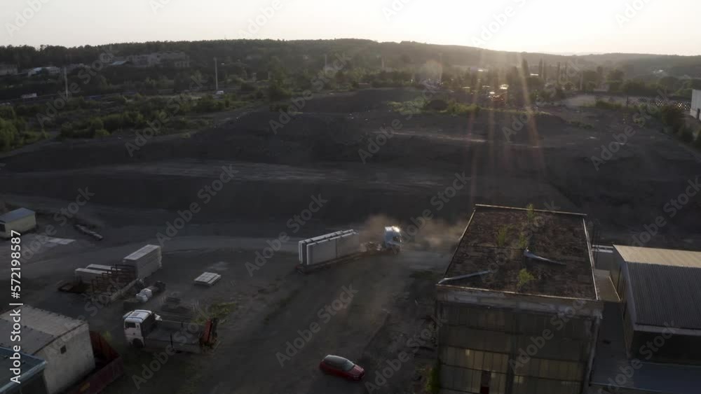 Trucks loaded with building material leaving factory quarry at sunset. Trucks loaded with building material leaving factory quarry at sunset.