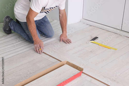 Man installing new laminate flooring indoors, closeup