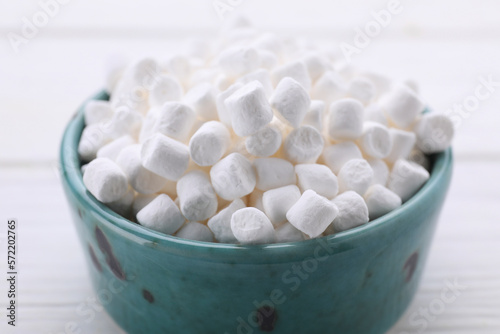 Bowl with delicious marshmallows on white table, closeup