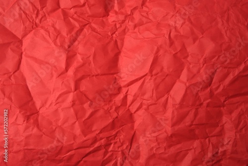 Sheet of crumpled red paper as background, top view