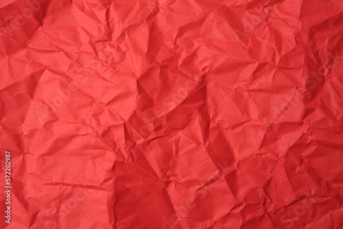 Sheet of crumpled red paper as background, top view