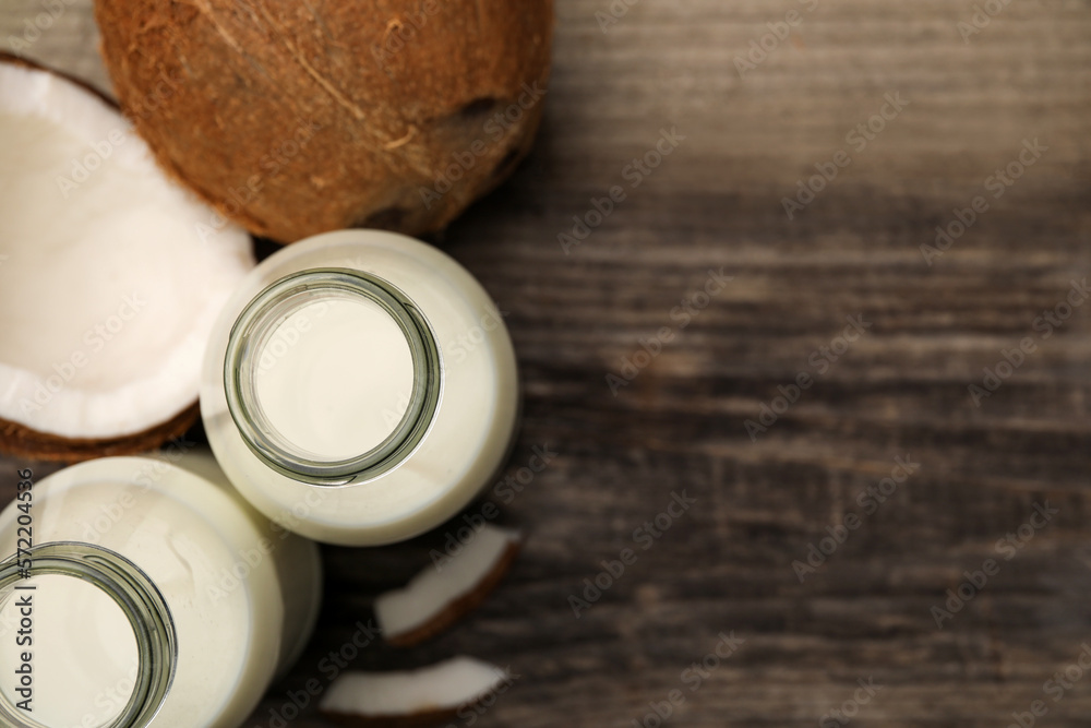 Delicious vegan milk and coconuts on wooden table, flat lay. Space for text Delicious vegan milk and coconuts on wooden table, flat lay. Space for text
