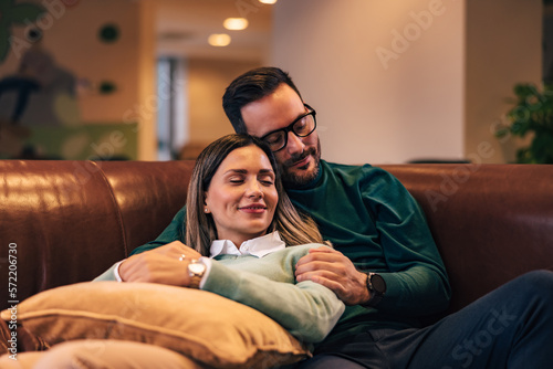 Business couple lying on the couch with closed eyes.