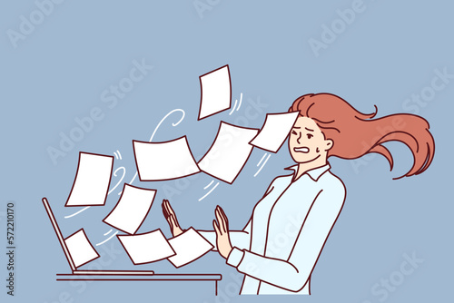 Woman working overtime is having trouble with large volume of documents or email flying out laptop screen. Secretary girl suffers from overtime and cannot cope with duties due to unprofessionalism photo