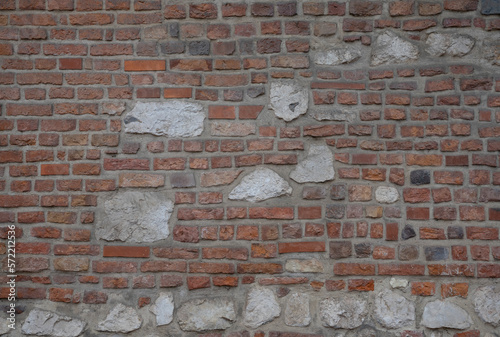 Antique red brick masonry with the addition of natural stones of different sizes and shapes