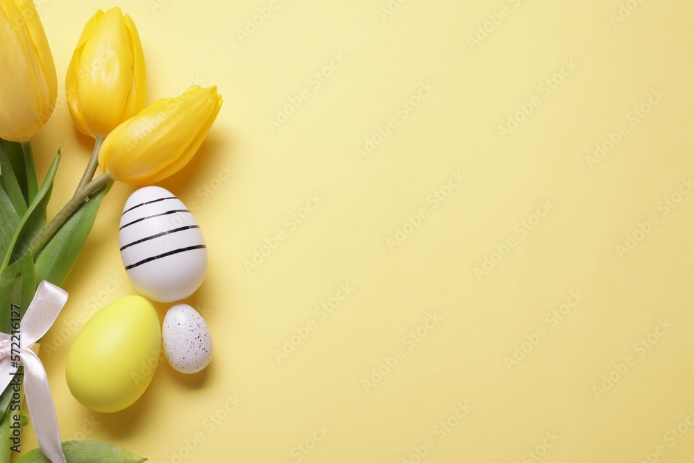 Flat lay composition with tulips and beautifully painted eggs on yellow background, space for text. Easter celebration Flat lay composition with tulips and beautifully painted eggs on yellow background, space for text. Easter celebration