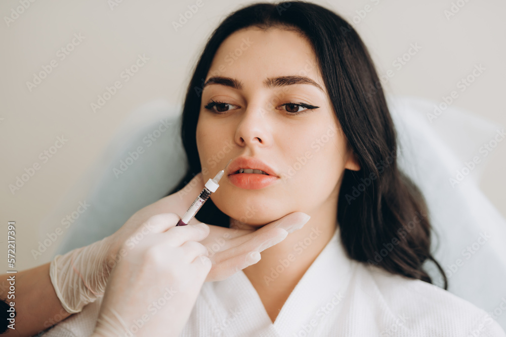 Attractive woman scared of injection. Girl looking with fear at a syringe. Anti-plastic surgery Attractive woman scared of injection. Girl looking with fear at a syringe. Anti-plastic surgery