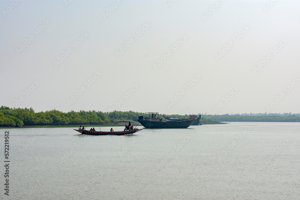 11th February, 2023, Sundarban, West Bengal, India: A man crossing river with his motor bike on a country boat at Sundarban Tiger Reserve.