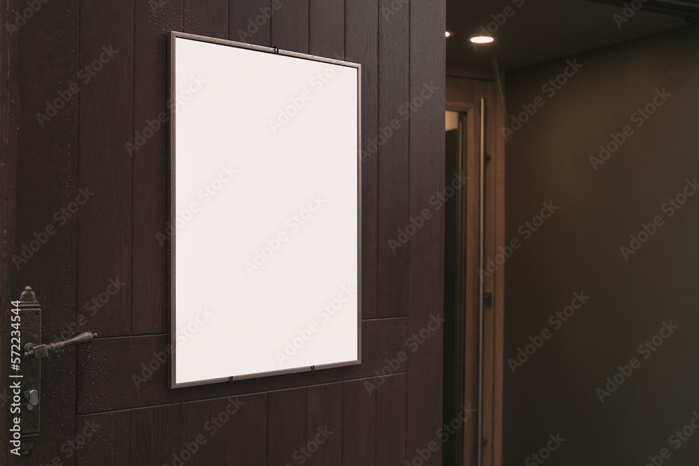 Empty menu board fixed vertically on wooden door of street cafe near building entrance. Frame with blank mock up space for customers message and information. Empty menu board fixed vertically on wooden door of street cafe near building entrance. Frame with blank mock up space for customers message and information.