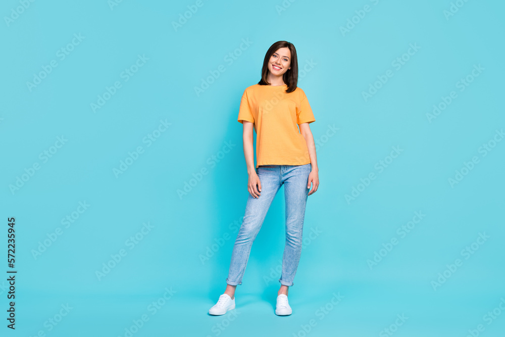 Full size portrait of satisfied glad young girl posing toothy smile isolated on blue color background Full size portrait of satisfied glad young girl posing toothy smile isolated on blue color background