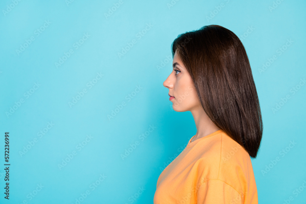 Profile portrait of gorgeous calm serious face girl look empty space isolated on blue color background Profile portrait of gorgeous calm serious face girl look empty space isolated on blue color background