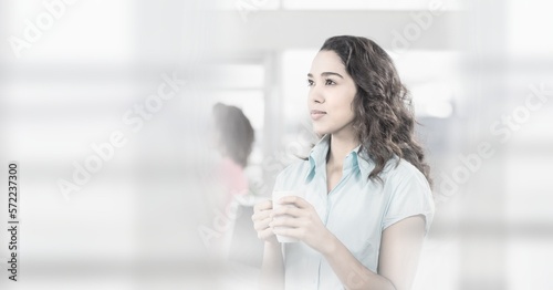 Composition of happy mixed race businesswoman holding mug with double exposure