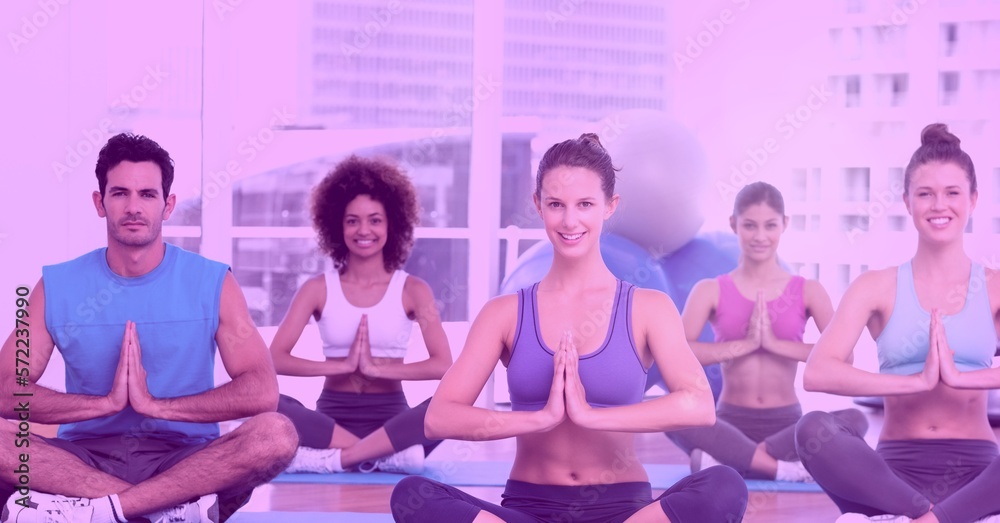 Man and women practicing yoga in studio on pink background Man and women practicing yoga in studio on pink background