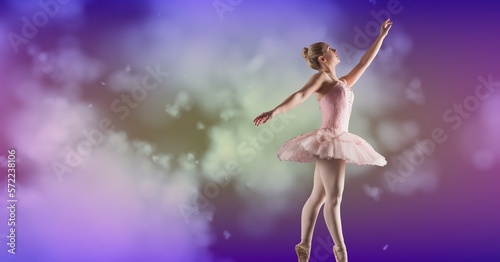 Composition of female ballet dancer in pink tutu with copy space on cloud over purple background